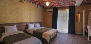 a hotel room with two beds and a window at Hotel BaniHills Tbilisi in Tbilisi City