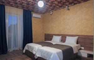 a bedroom with two beds and a window at Hotel BaniHills Tbilisi in Tbilisi City