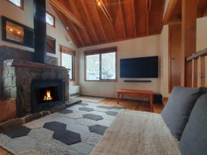 a living room with a fireplace and a flat screen tv at SNOWED INN apartment in Dinner Plain