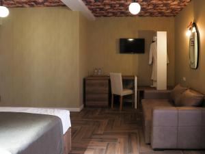 a hotel room with a bed and a couch and a table at Hotel BaniHills Tbilisi in Tbilisi City