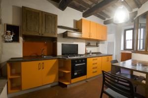d'une cuisine avec des armoires jaunes et une table. dans l'établissement Appartamento nel Borgo, à Roccatederighi