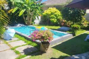 a small swimming pool in a yard with flowers at Samui Paradise Villa in Lipa Noi