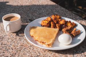 Nepalaya Home Hostel في كاتماندو: طبق من الطعام مع بيضة وكوب من القهوة