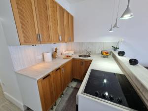 a kitchen with wooden cabinets and a stove top oven at Beach Serenity Studio on Makenzy in Larnaka +12 photos