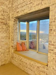 a window seat in a brick wall with two pillows at Lazy Sheeps Hostel in Hengchun South Gate