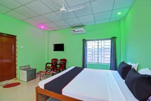 een slaapkamer met een wit bed en groene muren bij Collection O Mp Amorous Beach Resort in Mandarmoni