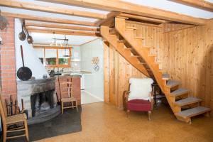 a kitchen with a wooden staircase and a fireplace at 5 room house Joch Churwalden- Lenzerheide in Churwalden