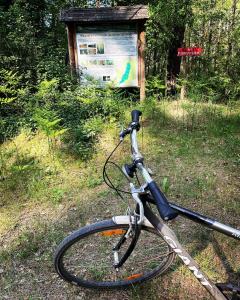 un vélo garé dans l'herbe à côté d'un panneau dans l'établissement Krasnogruda 7c, à Sejny