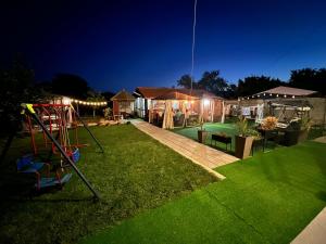 um quintal com um parque infantil à noite com luzes em House Varna-1 em Krapets