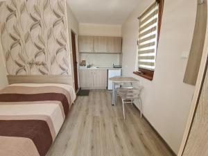凱拉派特的住宿－House Varna-1，带两张床和一张桌子的房间以及一间厨房