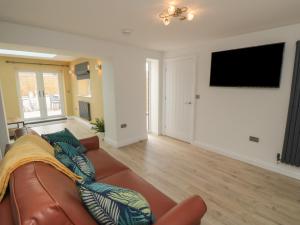 a living room with a couch and a flat screen tv at 2 Staveley Cottages in Weaverthorpe