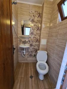 Un baño pequeño con inodoro y lavabo. en House Varna-1, en Krapets