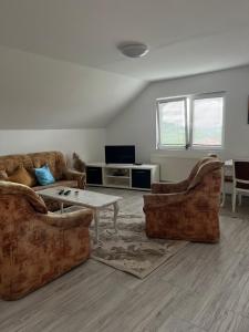 a living room with two couches and a table at Apartman Salus in Tuzla