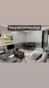 a living room with two beds and a table at LEPAK-LEPAK HOMESTAY @ INDERA MAHKOTA in Kuantan