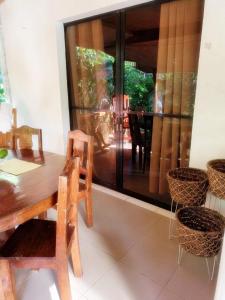 a dining room with a wooden table and chairs at Villagracia HomeStay 