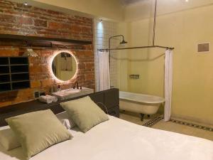 Casa Charlotte - Alma Hotels في سانتا مارتا: حمام به سرير وحوض استحمام ومغسلة
