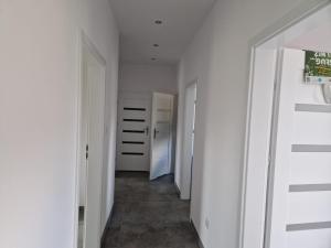 um corredor com paredes brancas e um corredor com portas brancas em GaLu- Trelkowko 1 em Kobyłocha