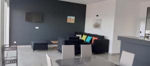 a living room with black chairs and a couch at Résidence ÉBÈNE - Villas in Antsakomboena