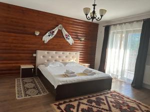a bedroom with a bed and a wooden wall at Casa Maramureșană in Vişeu de Sus