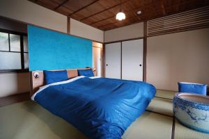 1 dormitorio con cama azul y pared azul en new! 熱海桃山邸　Atami terrace villa 〜Sauna & Onsen 〜 en Atami