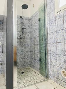 La salle de bains est pourvue d'une douche avec du carrelage bleu. dans l'établissement Ti kaz palmiers, à Saint-Pierre