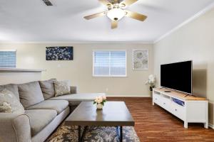 een woonkamer met een bank en een flatscreen-tv bij Seaworld Retreat Unwind Just Steps From The Action in San Antonio