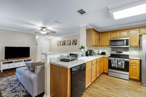a kitchen with wooden cabinets and a living room at Seaworld Retreat Unwind Just Steps From The Action in San Antonio