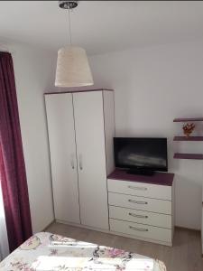a bedroom with a bed and a cabinet with a tv at Alina in Năvodari