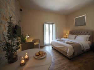 een slaapkamer met een groot bed en een tafel met kaarsen bij Terra Di Pietra Exclusive Suites & Apartments in Areopolis