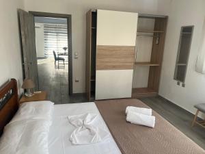 a bedroom with a white bed and a mirror at Village Dream-Rhodes Airport in Paradeísion