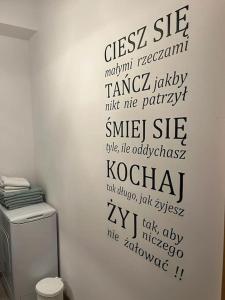 a wall with writing on the side of a toilet at Górnicza Wrocław in Wrocław