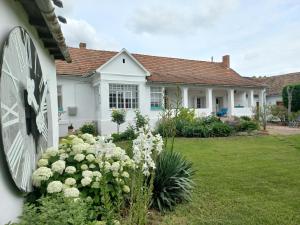 Tornácos Vendégház في هاجدوناناس: منزل به زهور بيضاء في الفناء