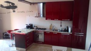 een keuken met rode kasten en een wastafel bij Marco Simone home in Marco Simone