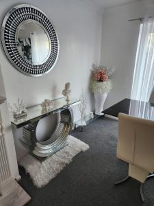 a living room with a mirror and a chair at Private luxurious space in Basildon