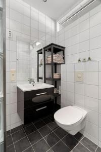 a white bathroom with a toilet and a sink at Seaview studio w/terrace&parking in Tromsø