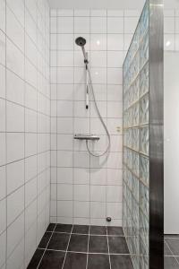 a shower in a white tiled bathroom at Seaview studio w/terrace&parking in Tromsø