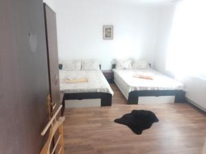 a bedroom with two beds and a rug on the floor at Vila Popoiu in Costinesti