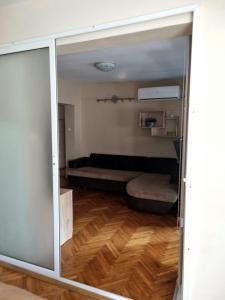 a sliding glass door leading to a room with a couch at Teodora Apartment in Ruse