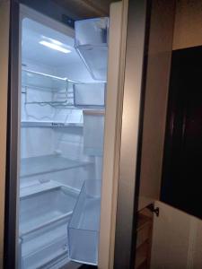 an empty refrigerator with its door open in a room at Teodora Apartment in Ruse