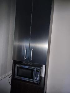 a microwave in a kitchen with a stainless steel cabinet at Teodora Apartment in Ruse