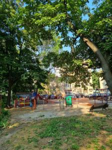 a park with a playground with trees and benches at Teodora Apartment in Ruse