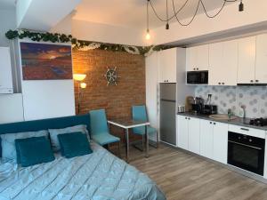 een slaapkamer met een blauw bed en een keuken bij Duo Apartament in Năvodari +9 foto's