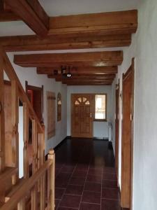 an empty hallway with wooden ceilings and a door at Alpesi kulcsos ház in Izvoru Mureşului