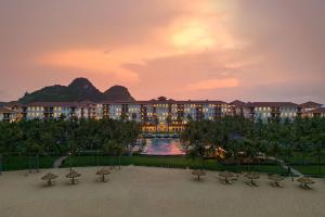 widok na ośrodek o zachodzie słońca z budynkiem w obiekcie Danang Marriott Resort & Spa w mieście Da Nang