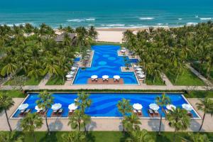 an aerial view of a resort with a pool and the ocean at Danang Marriott Resort & Spa in Danang