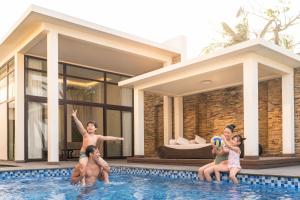 a group of people in the swimming pool of a house at Danang Marriott Resort & Spa in Da Nang