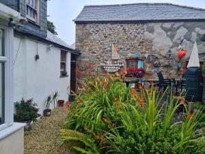 um jardim em frente a uma casa de pedra em Anvil House, The Old Forge em Saint Erth