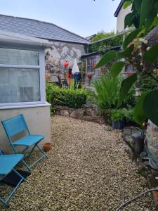 um quintal com uma cadeira azul e uma casa em Anvil House, The Old Forge em Saint Erth