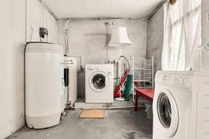 a laundry room with a washing machine and a washer at Dinbnb Apartments I Characteristic Townhouse with Bathtub in Bergen