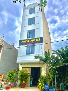 um edifício branco com um cartaz em Hotel Trang Huy em Thuan An